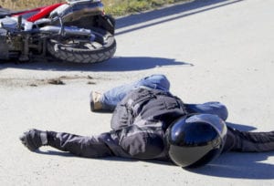 Motorcyclist laying on ground after accident